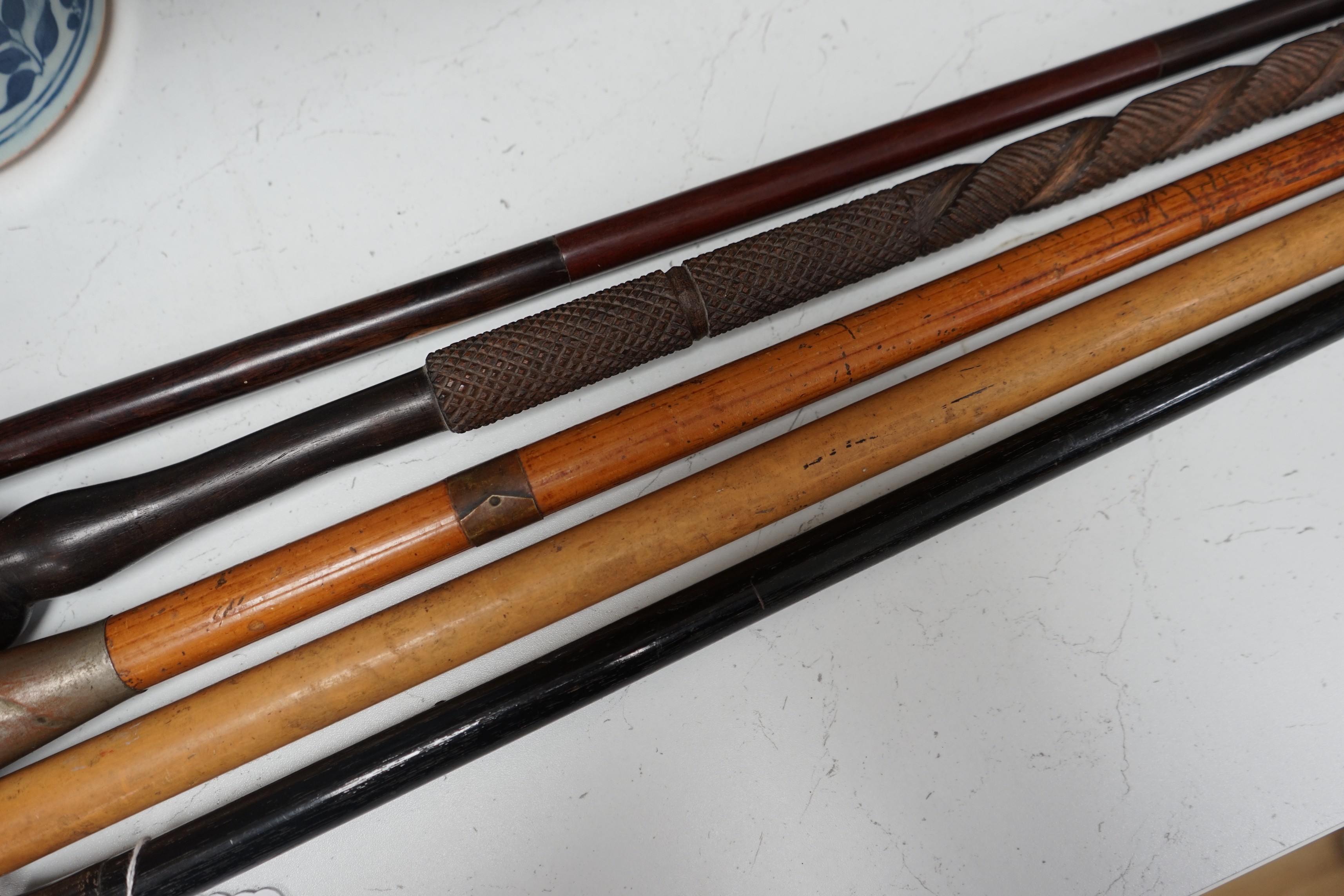 A collection of five walking sticks including one silver mounted and a Gladstone bag